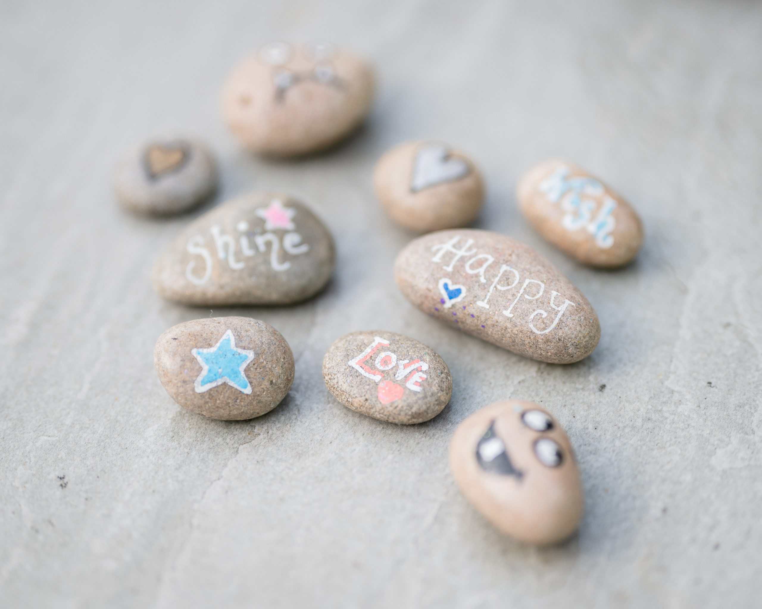 Decorated stones with motivational and loving messages for emotional support.